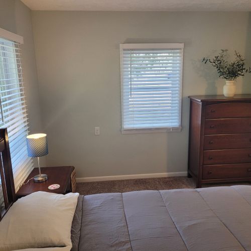 Bedroom #1:  features a queen-size bed, private en suite full bathroom, private television, walk-in closet, dresser, mirror, nightstands, and lamps