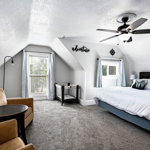 - serene top floor retreat with king bed, reading chair, and soft carpet underfoot
- sloped ceilings and natural light give this bedroom a cozy yet open feel
- perfect for relaxing after a long day with added privacy and charm