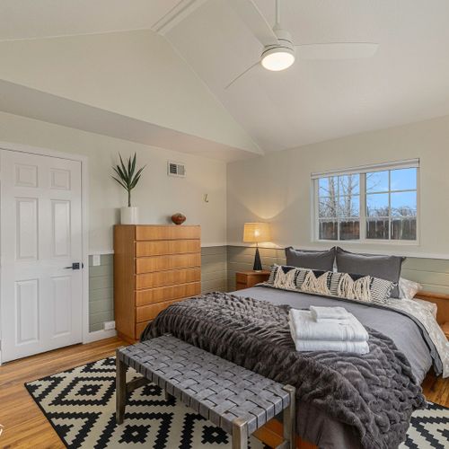 Retro bedside tables and lamps create a soft glow in the bedroom, perfect for late-night reading.