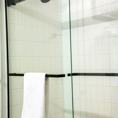 Step into a clean, glass-enclosed shower designed for a refreshing start to the day.