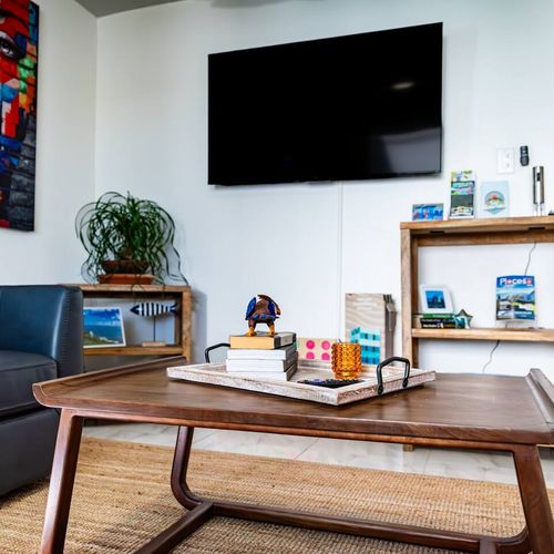 Relax in style in our inviting living area, complete with a large wall-mounted TV for your entertainment and a comfortable sofa.
