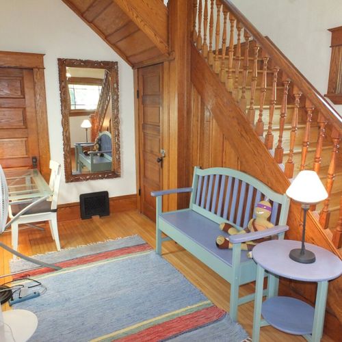 Front foyer:  the home has a beautiful front foyer, complemented by the wooden staircase with original woodwork. There is also a nice second desk in the foyer, which allows the home to work great for "work-cations".