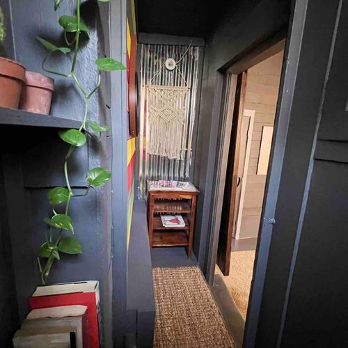 Lush greenery adds a refreshing touch to the bathroom's industrial aesthetic.