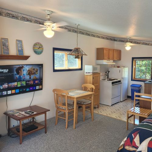 Main room:  the television and dining table with the kitchen in the background