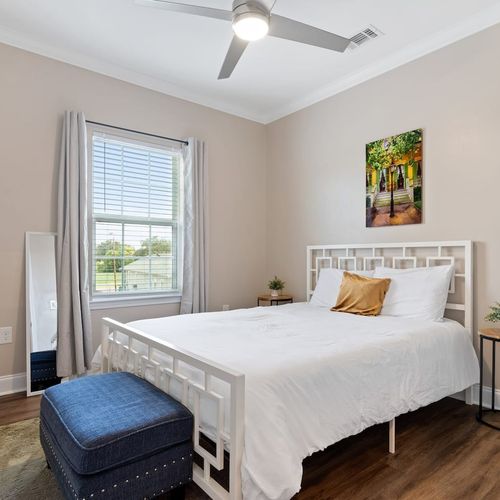 Airy queen bedroom w/ golden accents & natural light to wake up refreshed.
