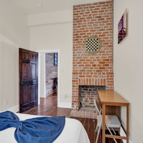 Original exposed brick fireplace bringing warmth & historic NOLA soul.
