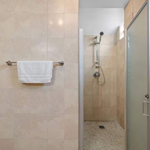 Experience comfort in a well-lit bathroom equipped with contemporary fixtures and a spacious shower area.