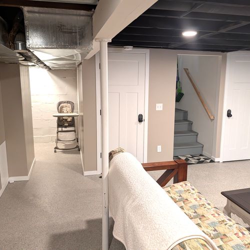 LIVING ROOM #3 (LOWER LEVEL):  Very fun third living room / game room in the basement with a futon, loveseat, coffee table, electric fireplace, and large screen smart television with live streaming. Note that this room is not to be used for sleeping.