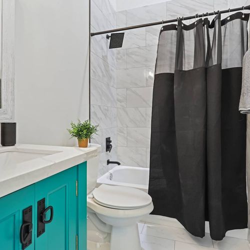 Teal-accented bathroom w/ a sink & bright, clean finishes.