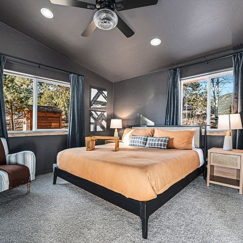 Relax in style in this spacious king bedroom, featuring elegant dark tones that create a calming, sophisticated atmosphere.