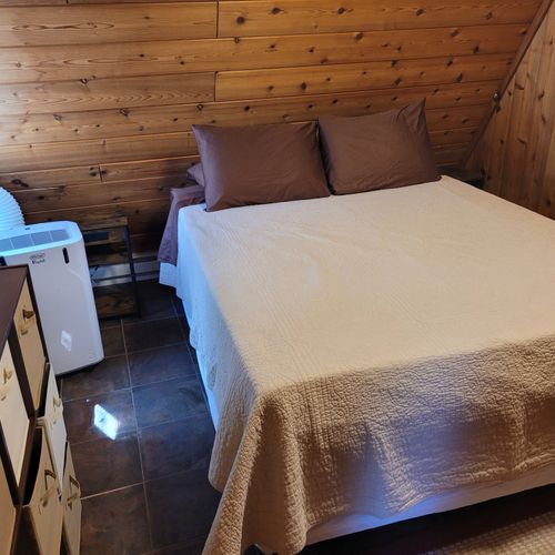 Bedroom #2 (main floor):  features a queen-size bed, portable a/c unit, closet, and drawers.