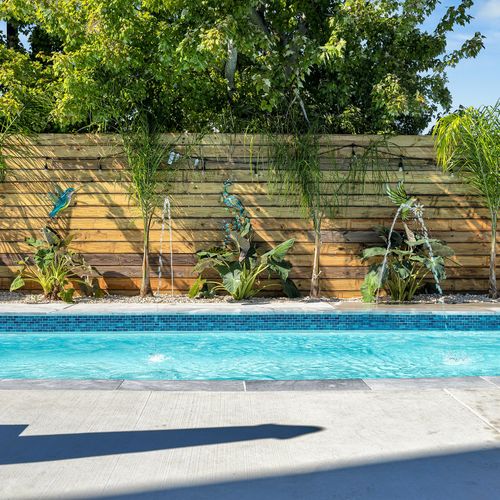 Take a refreshing dip in this serene pool, complete with playful fountains and tropical greenery for the perfect outdoor oasis.