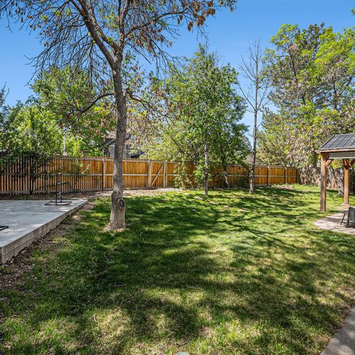 Sunny backyard oasis with covered patio—perfect for family cookouts and evening chats.