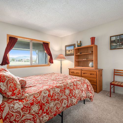 Relax in the master suite featuring a plush queen bed and mountain views.