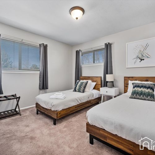 - comfortable twin bedroom with two separate beds, white bedding, and cozy carpet
- neutral tones and dual windows make this space ideal for kids or extra guests
- includes a luggage rack and nightstand for convenience during your stay