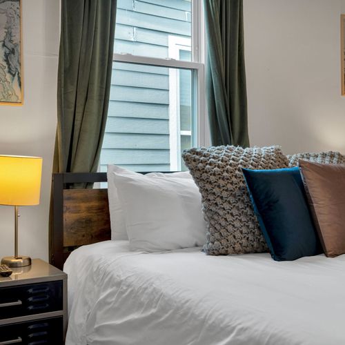 Soft, pillow-lined bed w/ warm lamplight — wake up slowly & settle in.
