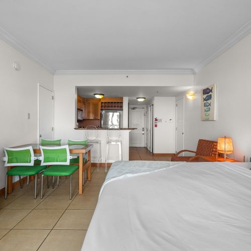 Spacious studio living with a view. This versatile space combines comfortable sleeping quarters, a dedicated dining area, and a cozy armchair – all within sight of the lagoon through the balcony doors.