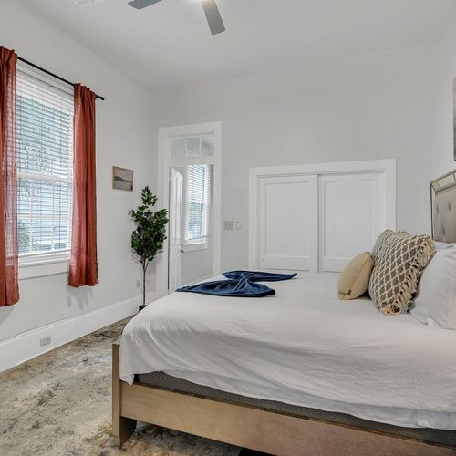 Sink into comfort in this stylish bedroom featuring a plush bed with a mirrored headboard and tasteful decor. Perfect for a restful night's sleep, this room combines luxury and relaxation for an unforgettable stay.