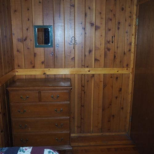Bedroom #2 (main floor):  features a queen-size bed, nightstand with a lamp, a dresser, and a closet.