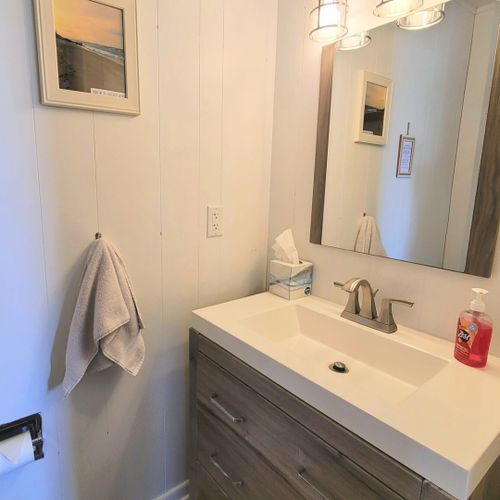 Half-bath:  conveniently entered into from the living room, there is a common half-bath with a sink, vanity, mirror, and toilet.