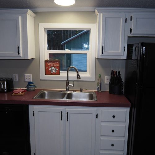 Another view of the kitchen showing the toaster, dishwasher, kitchen sink, and the refrigerator.