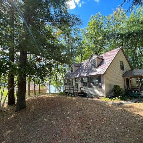 Overall:  the cabin, highlighting the large front yard and little twin lake in the background