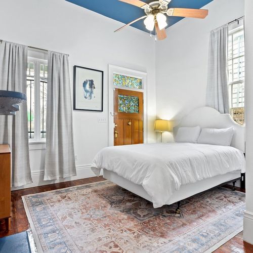 Sun-lit bedroom w/ a queen bed & warm wood tones for a restful night's sleep.