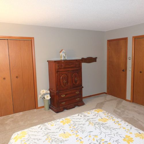 Bedroom #1:  features a queen-size bed, chair, nightstand, lamp, dresser, and 2 closets.
