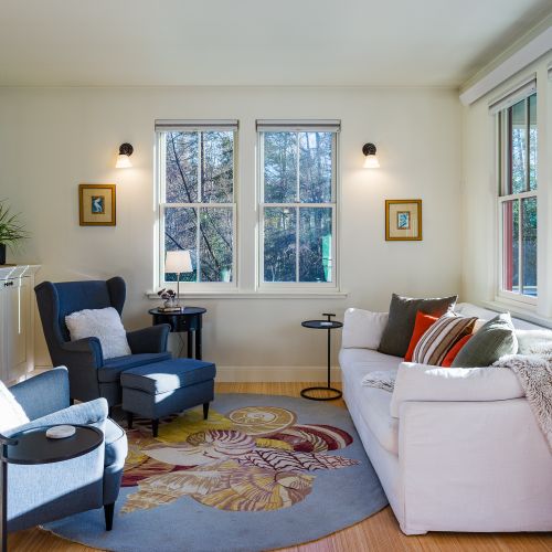 A sunlit living room with comfortable seating, ideal for relaxing, and reading.