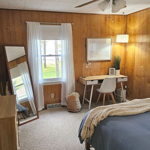 Bedroom #1:  features a queen-size bed, dresser, nightstand, lamp, ceiling fan, mirror, and desk.
