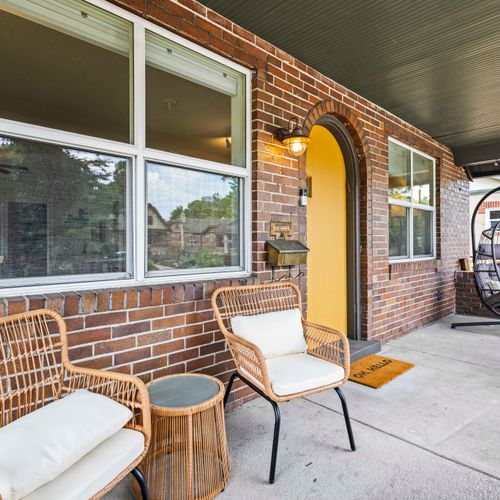 Cozy front seating welcomes you to enjoy the home’s fresh-air retreat.