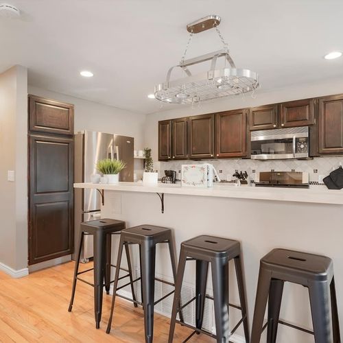 - dark wood cabinetry and sleek stainless steel appliances bring modern warmth
- enjoy quick bites or morning coffee at the long bar with seating for four
- open design allows guests to cook, snack, and chat without missing a moment