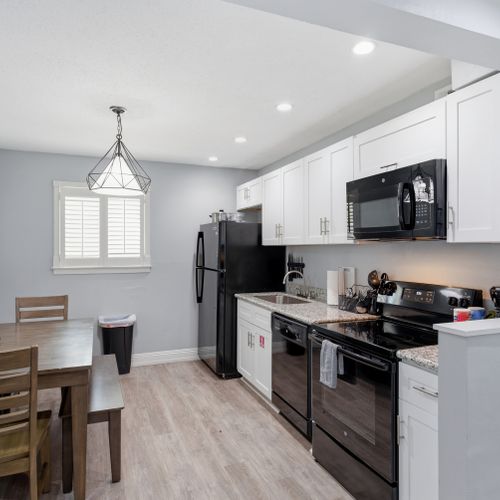 Cook with ease in this sleek, fully equipped kitchen w/ modern black appliances.