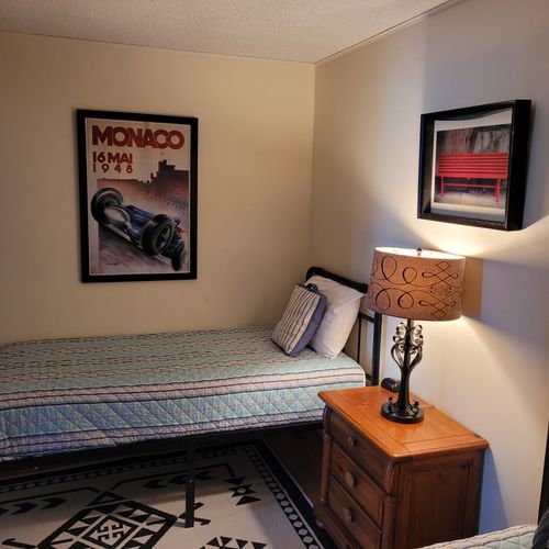 BEDROOM #3 (FIRST FLOOR):  Features two twin beds, a nightstand, lamp, dresser, and closet