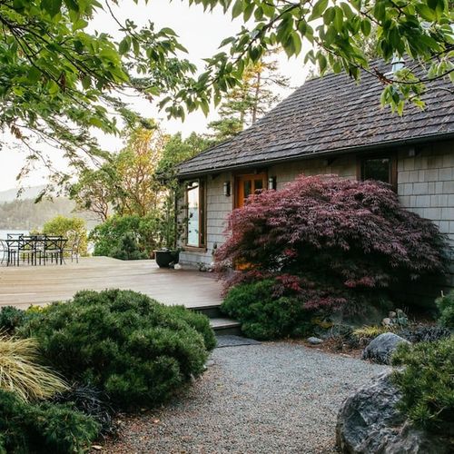 Beachfront with outdoor dining, hot tub, and boardwalk to the sandy beach below.