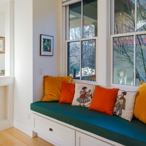 A charming window bench with plush cushions.