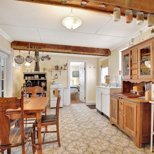 Homely kitchen with pine surfaces, white walls, and uncluttered storage design.