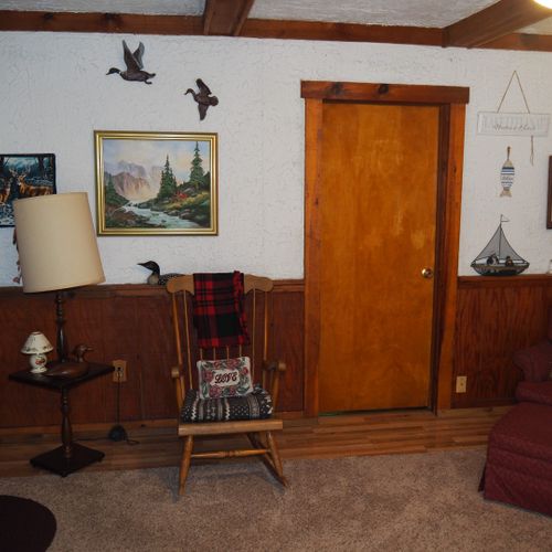 Living room:  includes a sofa, comfy chairs, live-streaming television, and entrance out to the deck.
