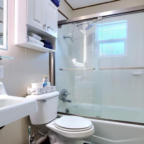 - start your day refreshed in a bright, stylish bathroom with a glass enclosed tub
- built in shelving keeps plush towels, toiletries, and decor neatly organized
- modern lighting and mountain themed touches make it feel warm and welcoming