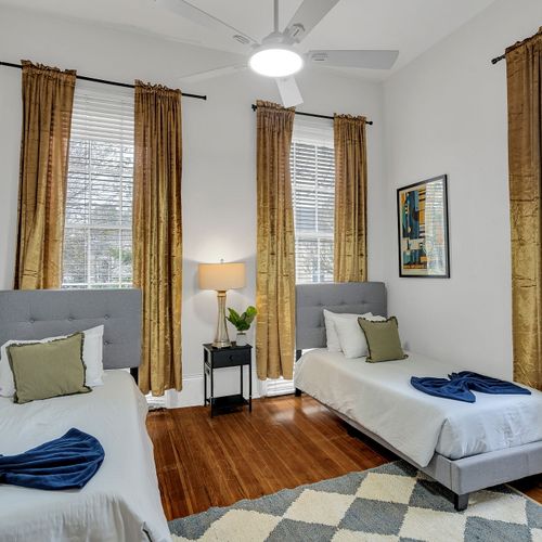 Spacious and airy twin bedroom with ample closet space and mirrored doors, adding to the room's open feel. Perfect for guests looking for a comfortable and stylish place to rest after exploring New Orleans.