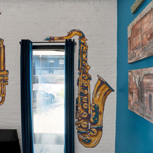 Gold saxophone wall art paired w/ expressive brushstrokes — pure New Orleans soul.