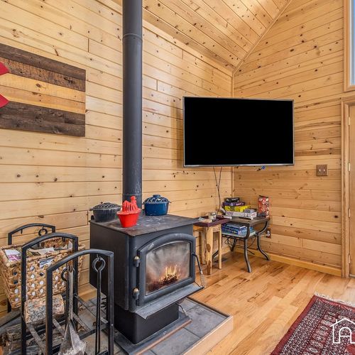 - snuggle up beside the wood burning stove for cozy nights with the fire crackling nearby
- mounted tv and entertainment table provide the perfect setup for movie marathons
- classic mountain style accents make this space feel inviting and warm