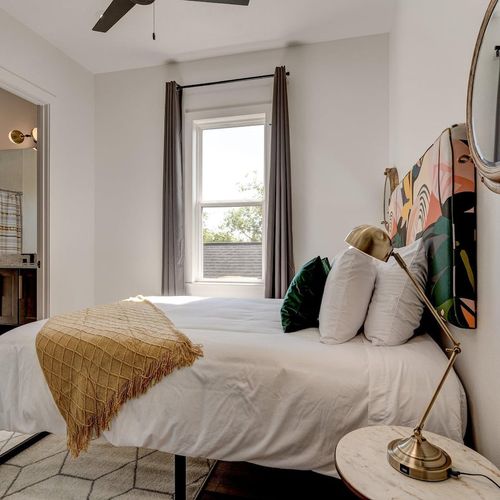 Bright upstairs bedroom w/ large window, natural light & a welcoming feel.