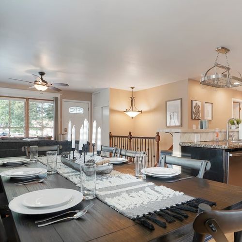 - spacious dining area with a long table and stylish place settings for eight guests
- open concept design allows conversation to flow from kitchen to living space
- share meals, toast the day, or host game night at this central gathering spot