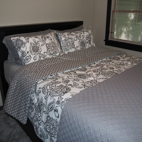 Bedroom #2 (main floor):  features a queen-size bed, ceiling fan, dresser, and closet.