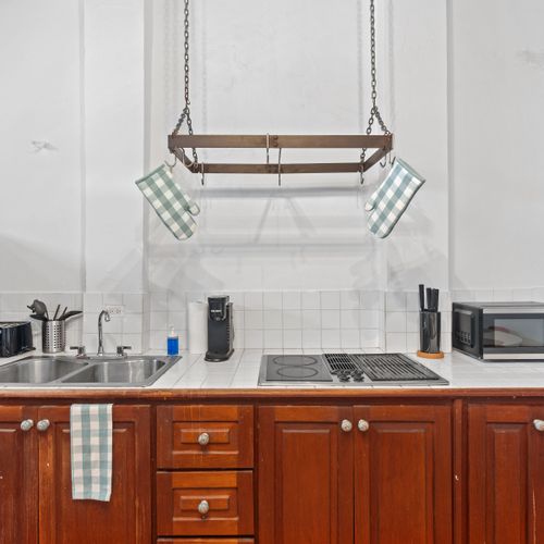 A cozy and functional kitchen equipped with an electric stove and all the essentials to make your stay effortless and enjoyable.