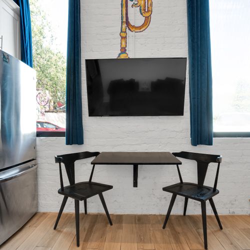 Dining area w/ a sleek table & wall-mounted TV — great for meals or movie nights.
