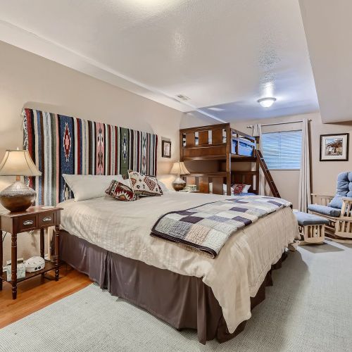 This lower level room has a king bed and twin-sized bunk beds. There is a full ensuite bathroom, cozy rocking chair and ottoman for extra seating.