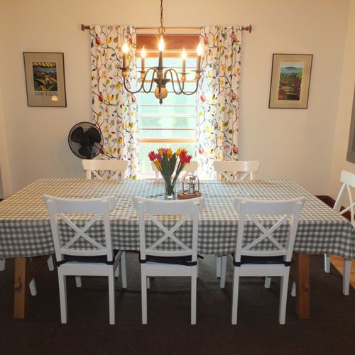 Dining area:  the dining table, chairs, and chandelier from another angle.