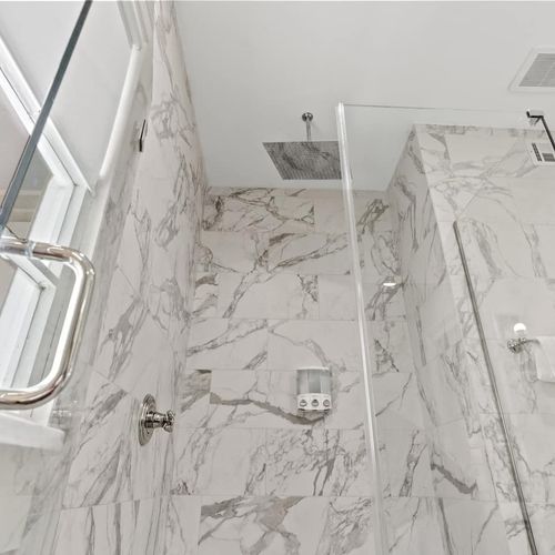 Stunning marble-look shower w/ rainfall-style fixtures — a luxurious rinse.